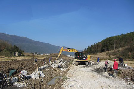 12月7日,民工在利川市南坪乡干堰村十组砌筑南堰河驳岸.