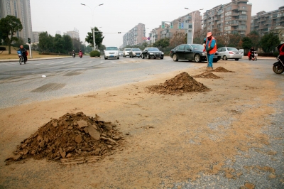 【组图】又是渣土车撒漏 数百米道路变土路 坑苦