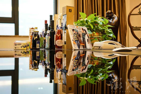 叶照辉办公桌上面放着各式蓝莓产业衍生品,还放了一张一家三口的合影。