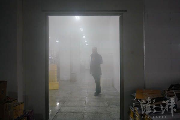 20叶照辉在生产车间视察,车间水蒸气弥漫。