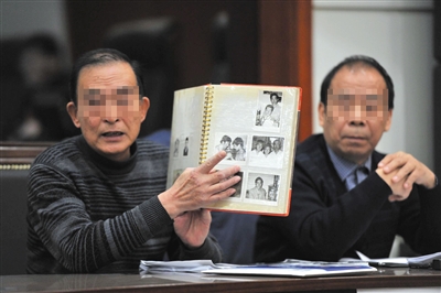 昨日,原告陈先生的父亲在法庭上出示被划坏的老照片。本版摄影/新京报记者 王贵彬