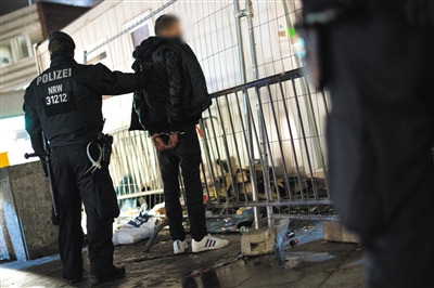 1月5日,在科隆火车站附近,警察正在对一名嫌疑人进行搜身。