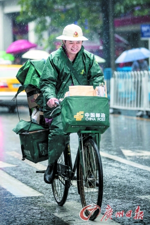 一德路,一名邮递员冒雨骑行.广州日报记者陈忧子 摄