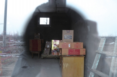 记者隔窗拍摄到林场空房内存放违禁烟花爆竹。