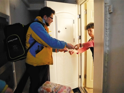 远洋天地小区,弗兰克将快递送到顾客手中。