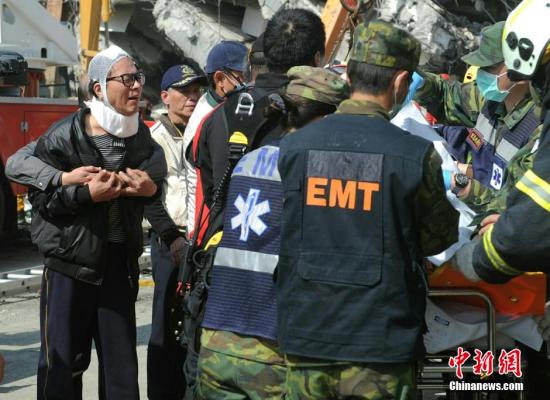 2月7日，因台湾南部6.7级地震而倒塌的维冠大楼救援行动持续，有市民(左)目睹至亲罹难，悲痛落泪。中新社记者 谭达明 摄