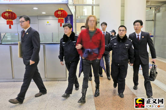 王某(中)走出机场后被办案人员带走,成为今年上海市首例经劝返回国自首的外逃人员。 正义网 图