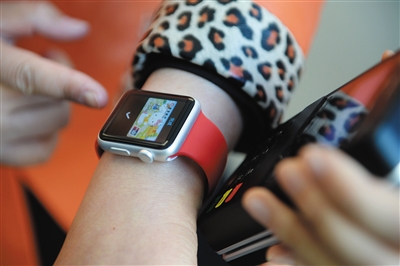 2月18日,北京王府井购物中心,体验者用Apple Watch靠近POS机刷卡消费。