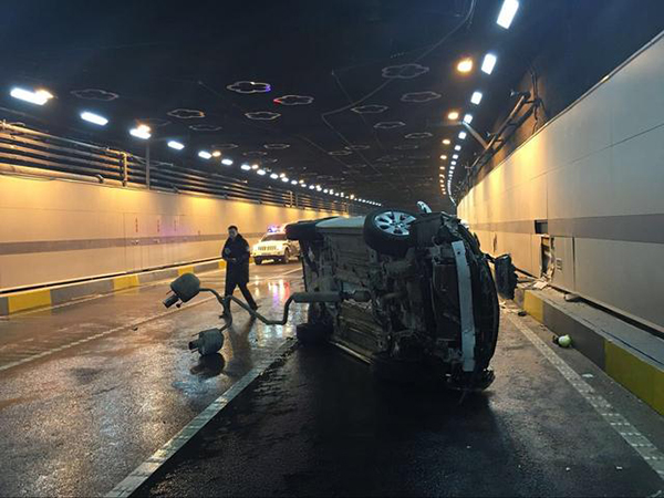 事故车辆侧翻在现场1消防人员对现场进行处理一辆白色小轿车装上隧道