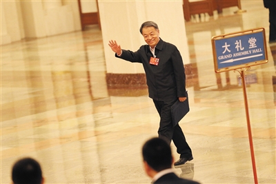 昨日，人民大会堂北门通往正厅的“部长通道”上，交通部部长杨传堂跟记者们打招呼。新京报记者 薛�B 摄