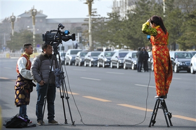 开幕后 记者在人民大会堂外现场报道。新华社发