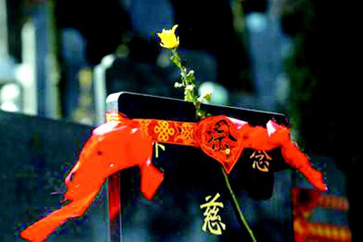 1日,安陆市白兆陵园管理处,群众自发地用香烛纸炮兑换鲜花和祈福带