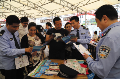 百支小分队参与多项公益普法(图)民警在活动现场给市民宣传治安防范