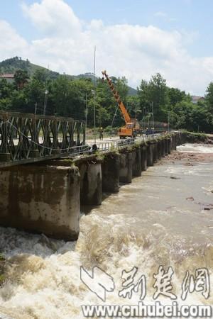 被洪水冲垮的叶家湾大桥断桥上正在架设钢桥