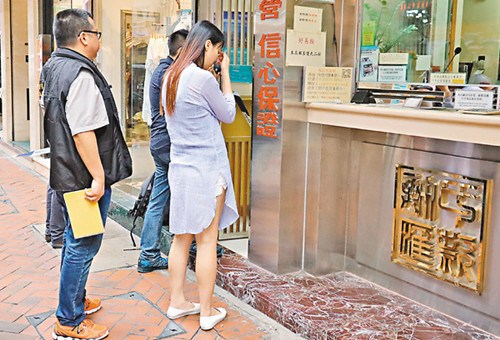 兑换店女职员(右一)在场协助调查。(图:香港《文汇报》/刘友光 摄)