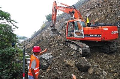 工作人员在现场清理塌方,预计二三十天恢复通车。新京报记者 王嘉宁 摄