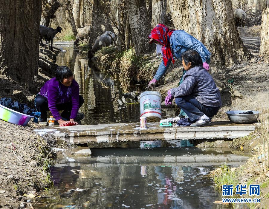 在吐鲁番地区鄯善县七克台镇台孜村一条坎儿井明渠边上，三位江苏支边青年的后裔在洗衣服（4月3日摄）。 新华社记者 赵戈 摄
