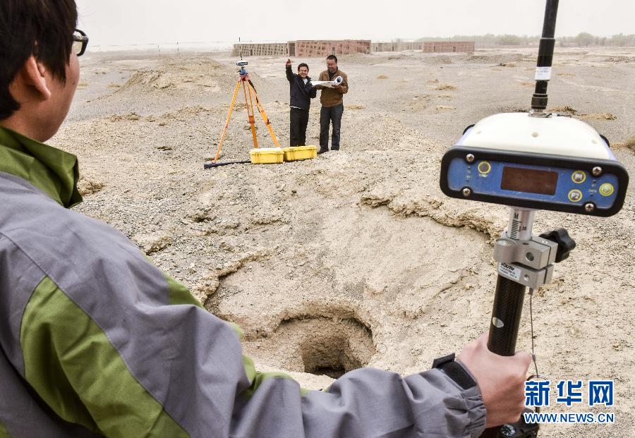 在吐鲁番市艾丁湖乡花园村，吐鲁番地区文物局的工作人员在利用卫星定位仪对坎儿井进行测量（4月2日摄）。 新华社记者 赵戈 摄