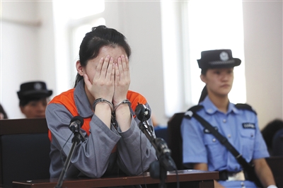 2013年5月30日,涉嫌虐待继女的蔡某在朝阳法院受审时,不时双手捂面。之前她采用手掐、脚踹、开水烫等方式虐待孩子。新京报资料图片/王贵彬 摄