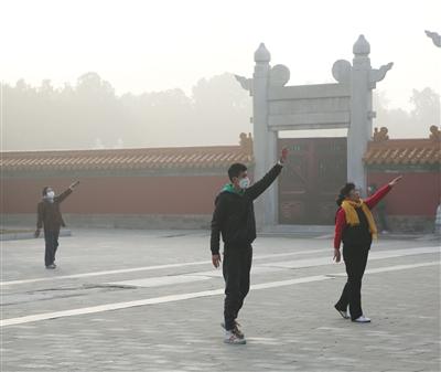 地坛公园,市民戴着口罩晨练。本版图片/视觉中国