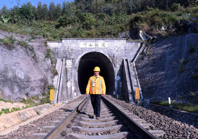廖成根在邓山隧道外巡查铁路(12月6日摄)。