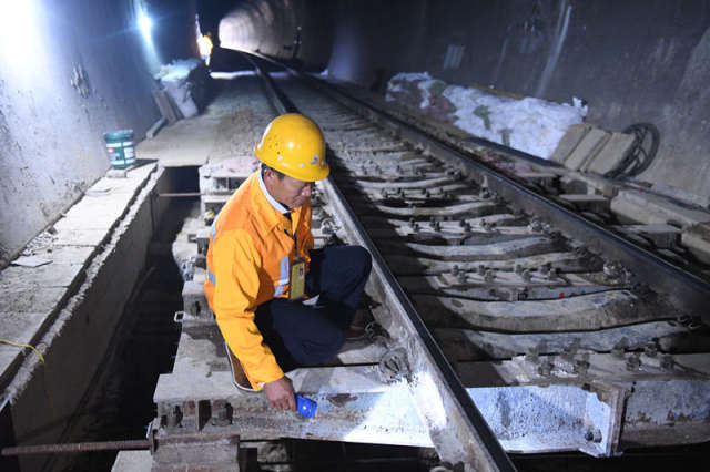 廖成根在邓山隧道内检查铁轨状况(12月6日摄)。