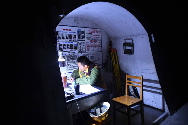 廖成根在邓山隧道内的工作间做记录(12月6日摄)。