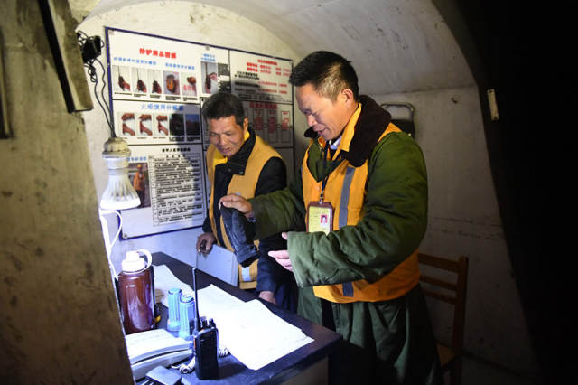 廖成根(右)在黔桂铁路广西宜州市德胜镇境内的邓山隧道与梁志辉交接(12月6日摄)。