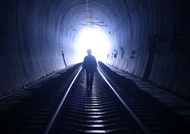 廖成根在黔桂铁路广西宜州市德胜镇境内的邓山隧道巡查(12月6日摄)。