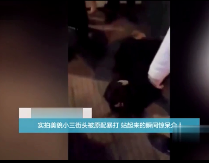 图为视频截图，小三躺在地上，抱头护脸。