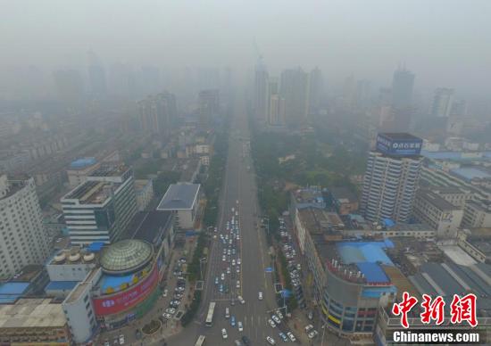 1月2日,湖南长沙火车站被雾霾笼罩。据湖南省环境保护厅监测数据,当日10时,湖南市州空气质量出现不同程度的污染,长沙、常德、张家界等6市PM2.5浓度超过150微克/立方米,达到重度污染。图为长沙火车站前的五一大道能见度低。 杨华峰 摄