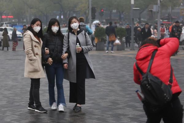 2016年11月18日,北京三里屯,三位女生戴着口罩在太古里街拍。 澎湃新闻记者 谢匡时 图