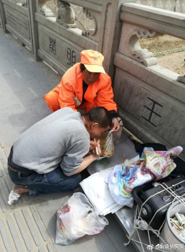 保洁员正在帮一位肢体残疾的小伙子撑开盛饭的塑料袋，方便残疾人吃饭。 本文图片均为@华商报 图