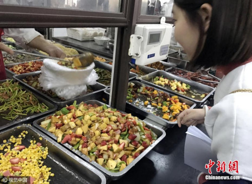 资料图：学生在校食堂窗口前买餐。视觉中国