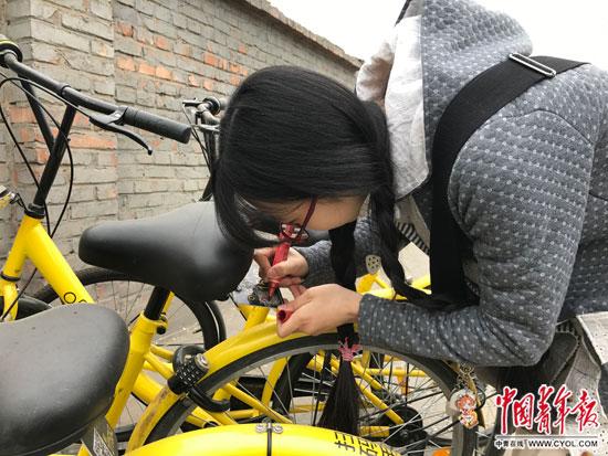 李冬雨在北京街头为被划掉多位数字的共享单车补牌。中国青年报中青在线记者 李想/摄