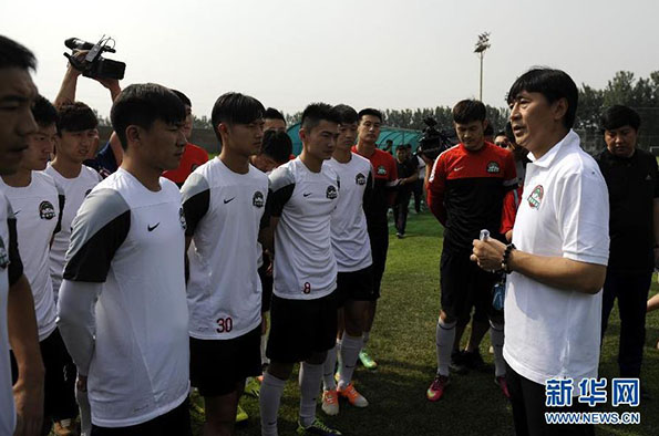 河南建业队主教练贾秀全（前右）在训练场上指导球员。新华网 资料图