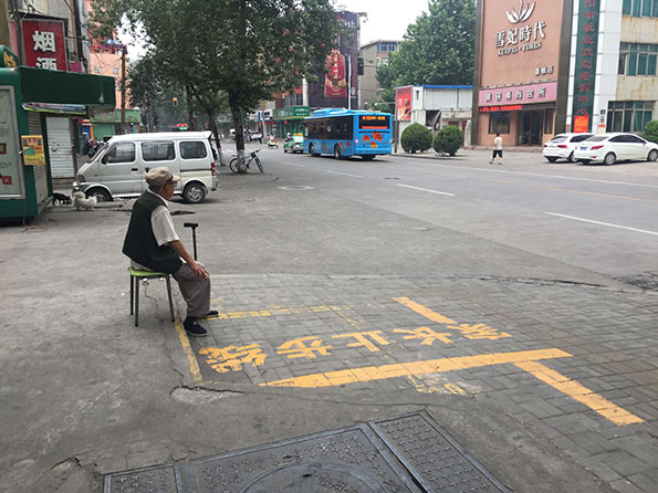 清晨6点洛阳街头，一位大爷坐在街边听收音机。