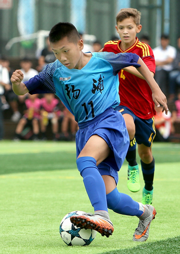 6月28日，上海杨浦队球员（前）在比赛中带球突破。新华网 图